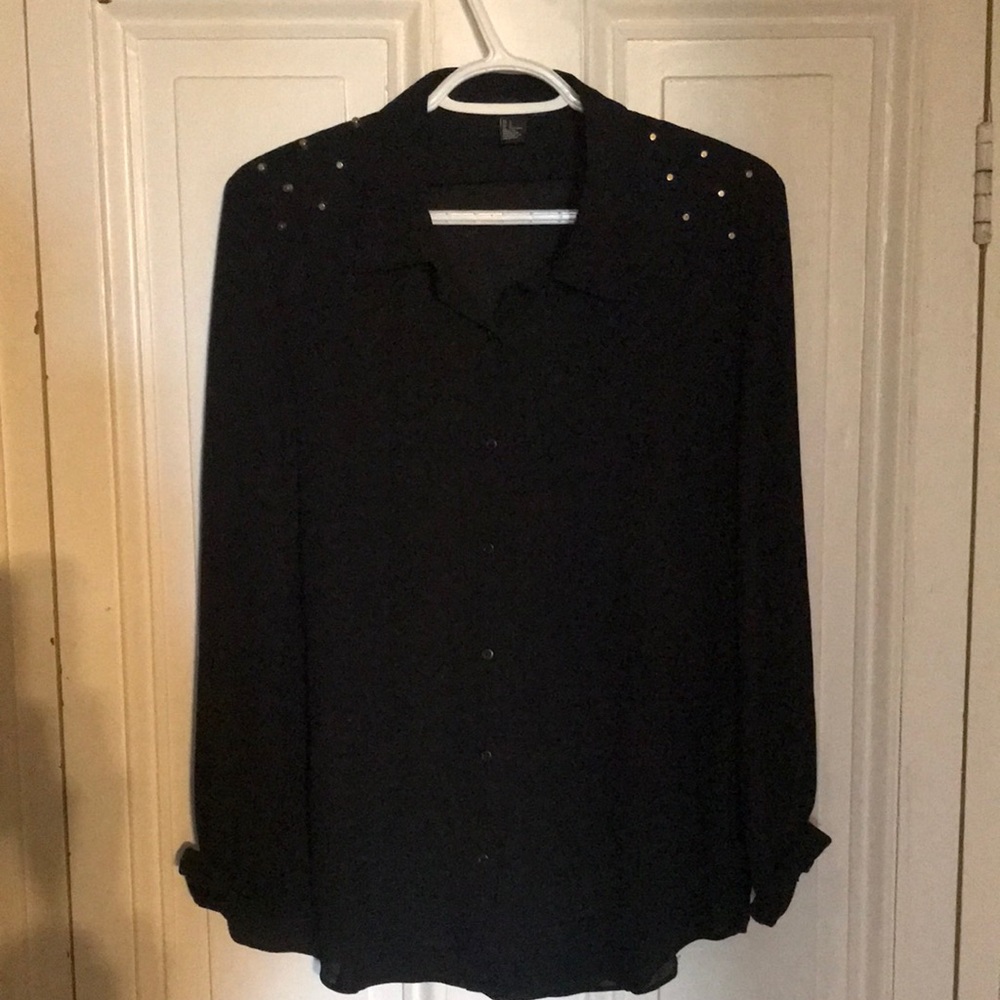 Black blouse with gold studs on the shoulders.